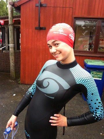 Poppy as a young competitive swimmer, in a wetsuit and swim cap